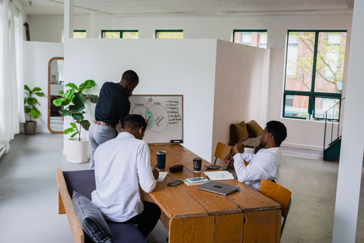 Des collègues examinent ensemble un plan d’affaires dans un espace de travail lumineux